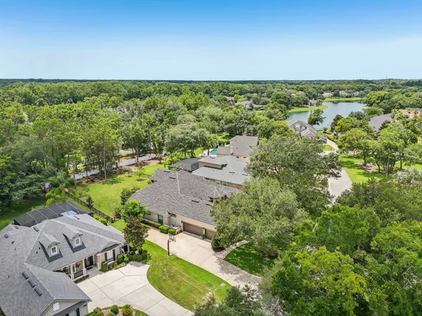 an aerial view of residential house with outdoor space and trees all around