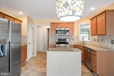 a kitchen with stainless steel appliances a sink stove refrigerator and cabinets