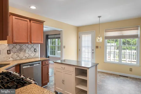 a kitchen with granite countertop a stove and white cabinets