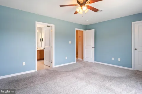an empty room and chandelier fan