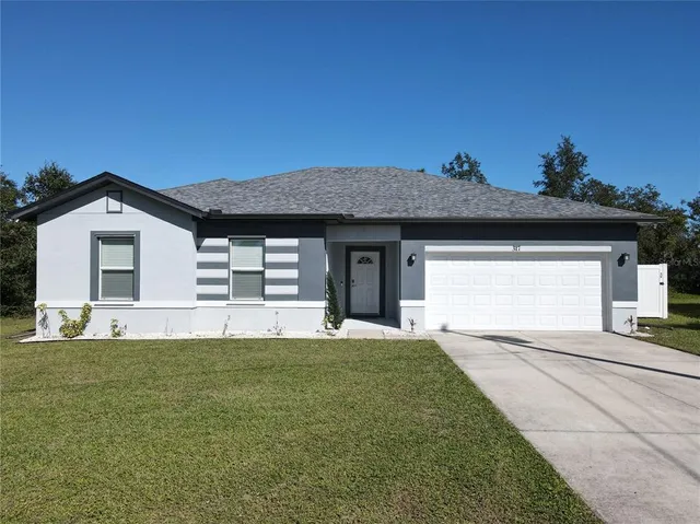 a front view of a house with a garden and yard