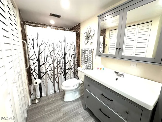 a bathroom with a sink a toilet and a large mirror