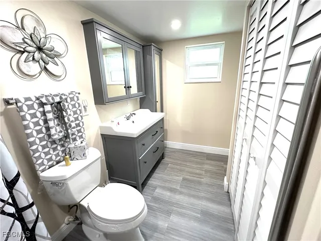 a bathroom with a sink a toilet a mirror and shower