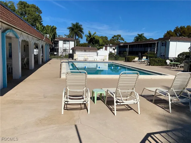a view of a patio with dining table and chairs with a swimming pool