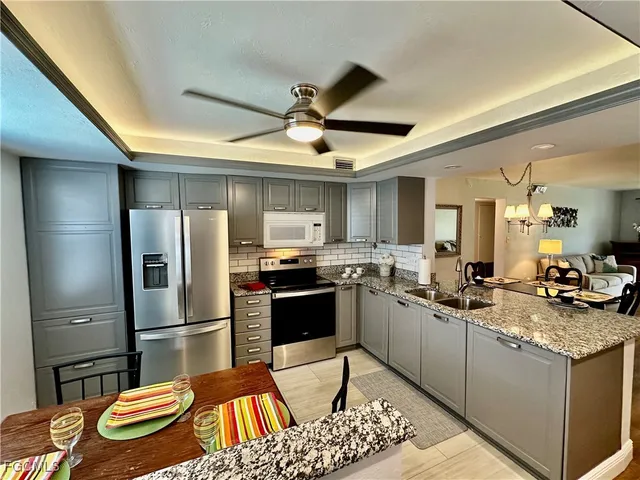 a kitchen with stainless steel appliances granite countertop a sink and a refrigerator