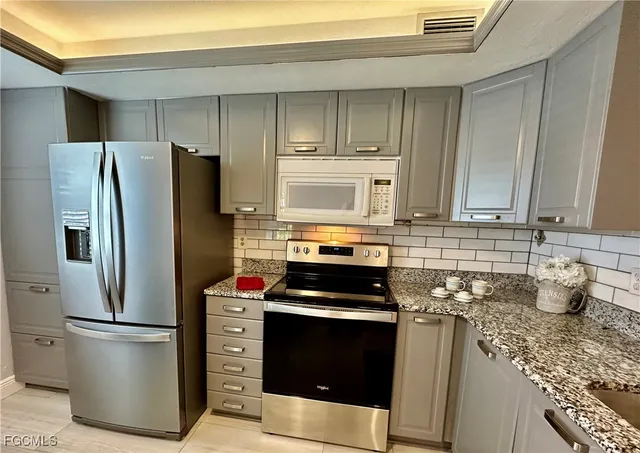 a kitchen with a refrigerator stove and cabinets