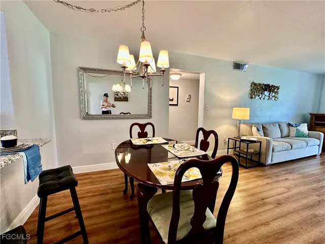 a view of a dining room with furniture a chandelier and wooden floor