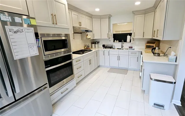 a kitchen with white cabinets and white appliances