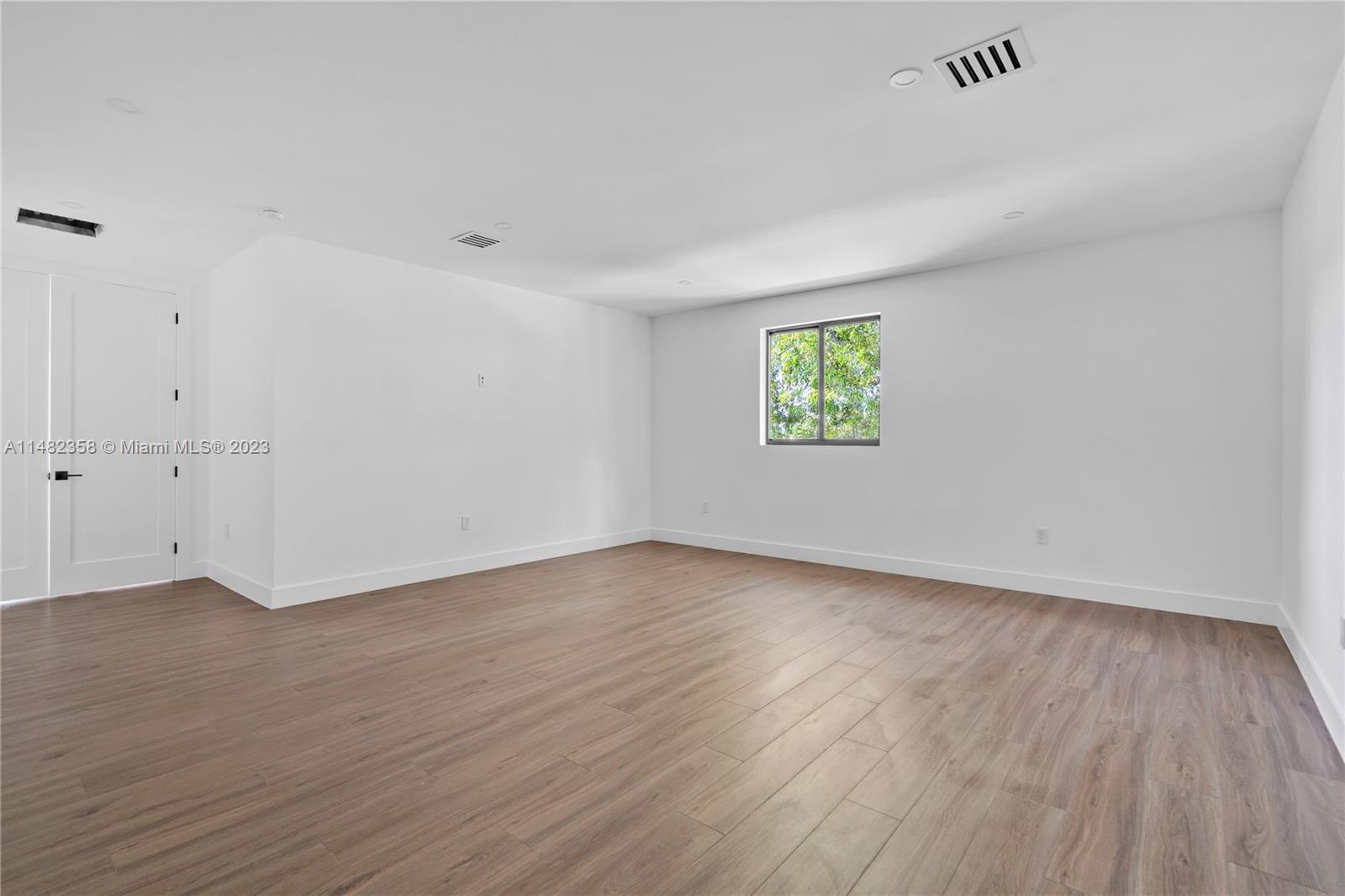 5241 Southwest 6th Street Miami, FL 33134 - Photo 34 of 38 a view of an empty room with wooden floor and a window