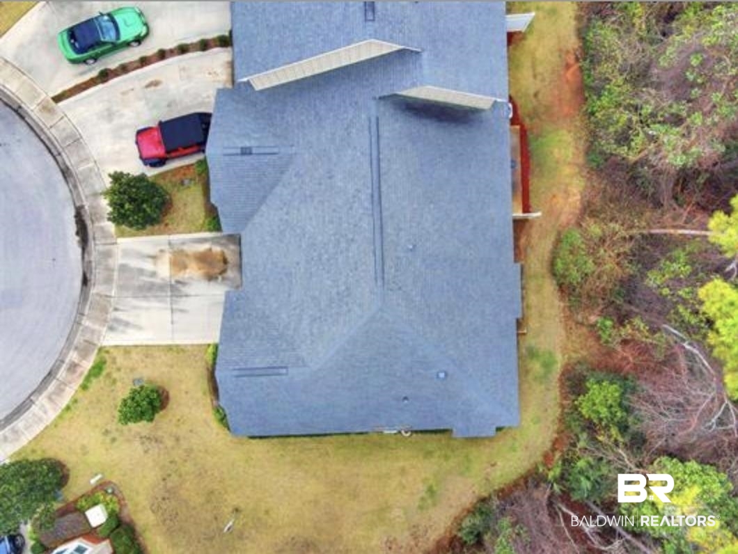 430 West Fort Morgan Road Gulf Shores, AL 36542 - Photo 7 of 27 Residential property featuring a dark shingle roof and a concrete driveway leading to a cul-de-sac