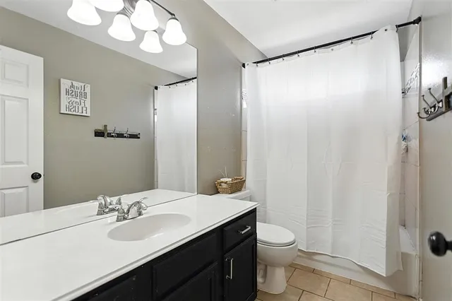 a bathroom with a double vanity sink mirror and toilet