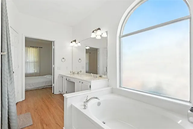 a bathroom with a bathtub shower and a sink