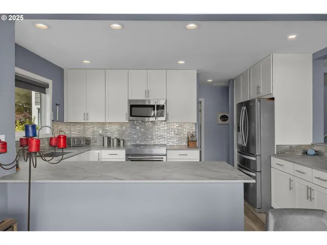 a kitchen with stainless steel appliances granite countertop a sink refrigerator and microwave