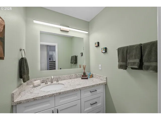 a bathroom with a granite countertop sink and a mirror