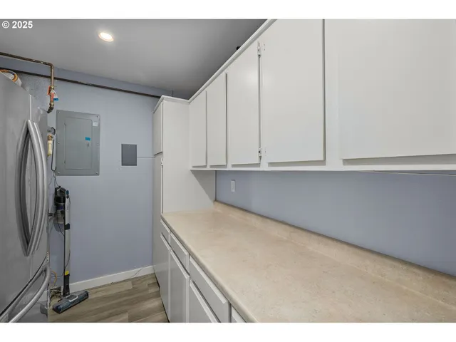 a kitchen with a refrigerator and white cabinets
