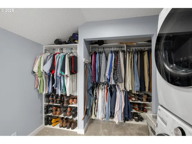 a view of walk in closet with clothes and shoes