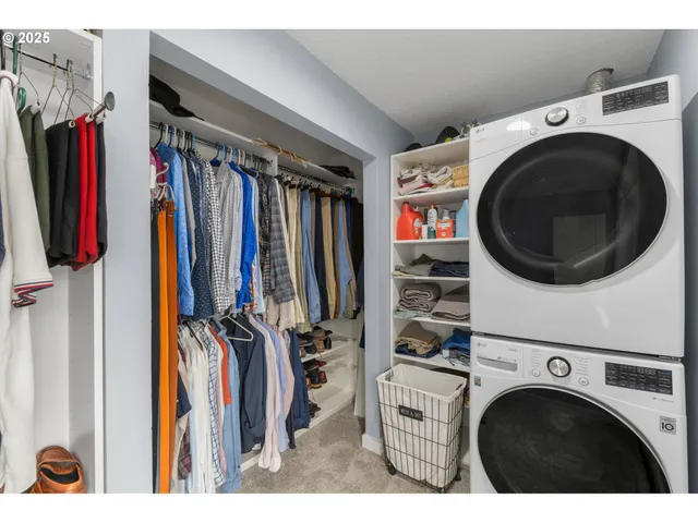 a view of walk in closet with clothes and shoes