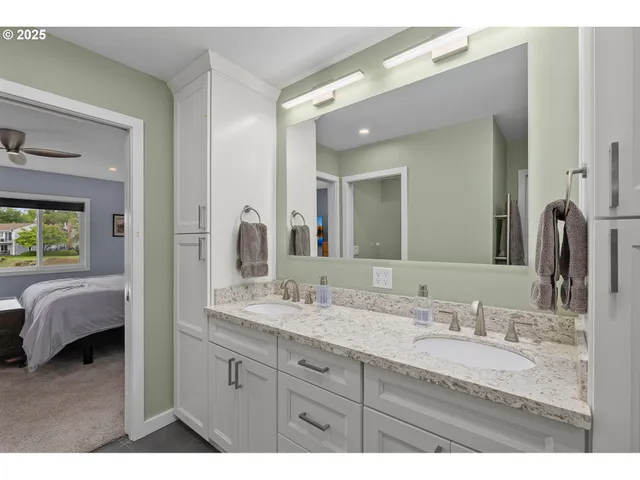 a en suite bathroom with a granite countertop sink and a mirror