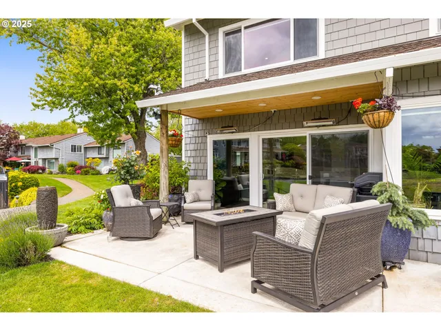 a view of a patio with couches table and chairs and potted plants
