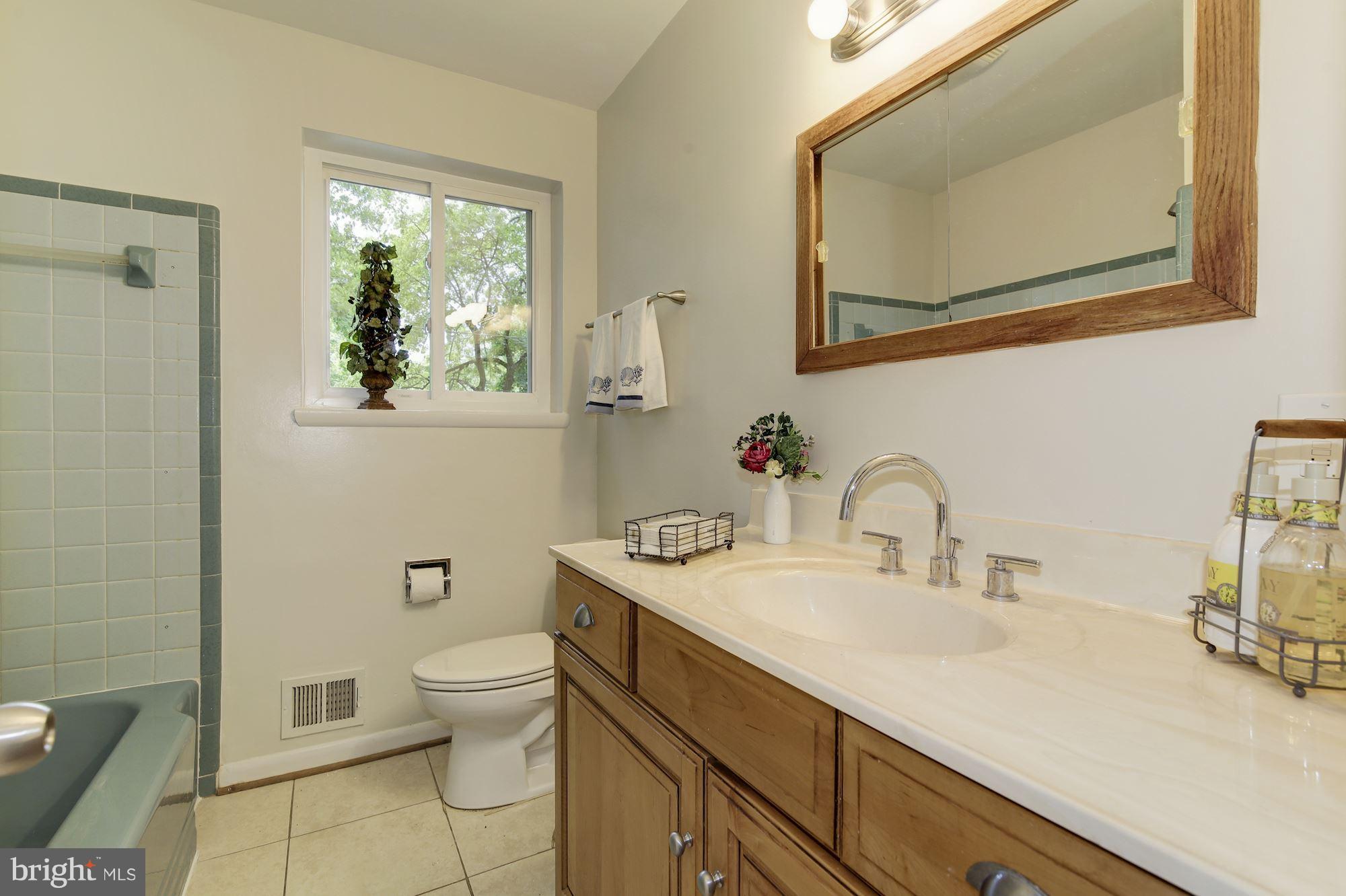 10709 Glenwild Road Silver Spring, MD 20901 - Photo 13 of 30 a bathroom with a granite countertop sink a toilet and a mirror
