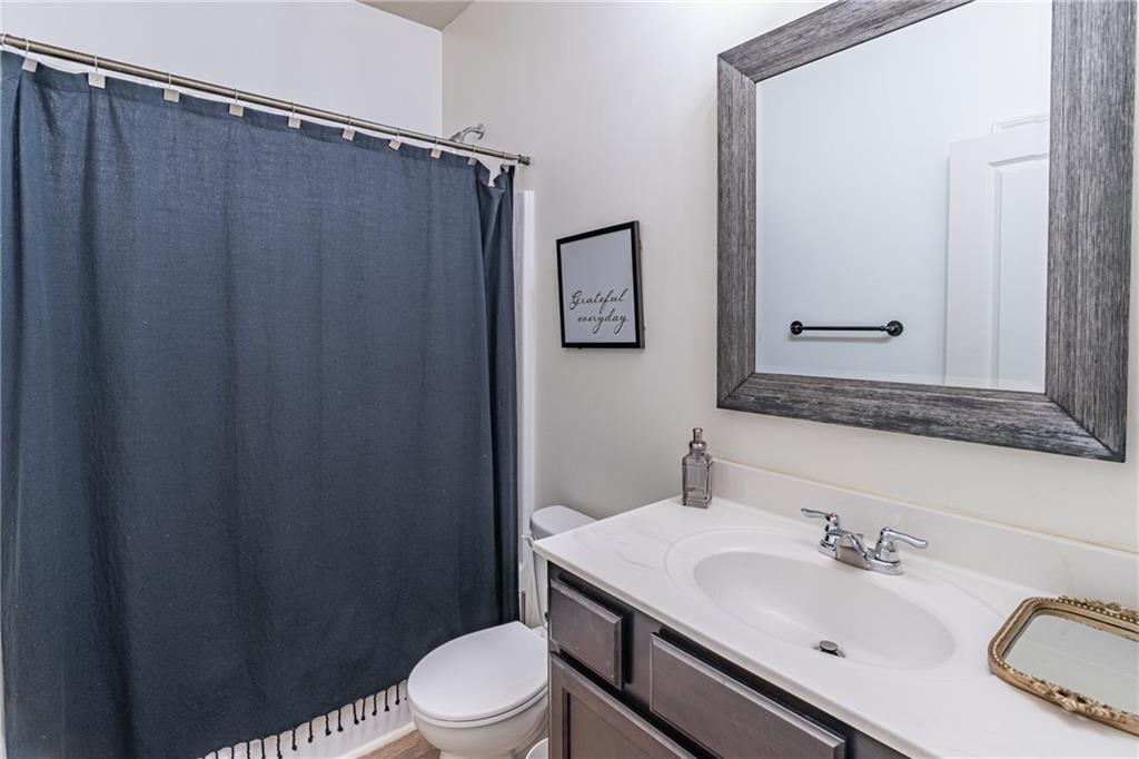 723 Independence Avenue Pendergrass, GA 30567 - Photo 15 of 22 a bathroom with a sink a toilet a mirror and shower curtain