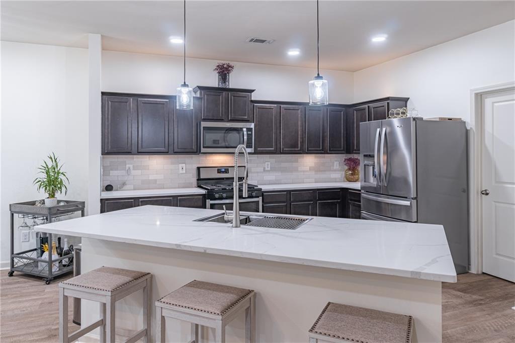 723 Independence Avenue Pendergrass, GA 30567 - Photo 8 of 22 a kitchen with kitchen island a counter space a sink appliances and cabinets