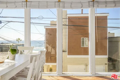 a view of a dining room with furniture large windows and wooden floor