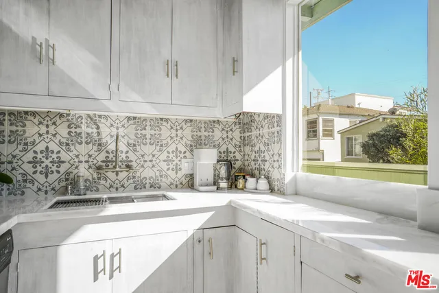 a dining room with furniture a chandelier and large window