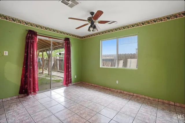a view of empty room with window and ceiling fan