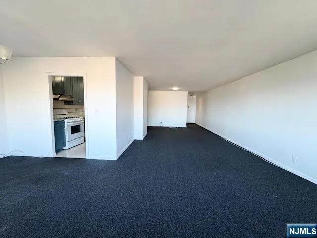 a view of empty room with kitchen