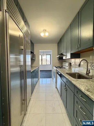 a large kitchen with stainless steel appliances granite countertop a sink and cabinets