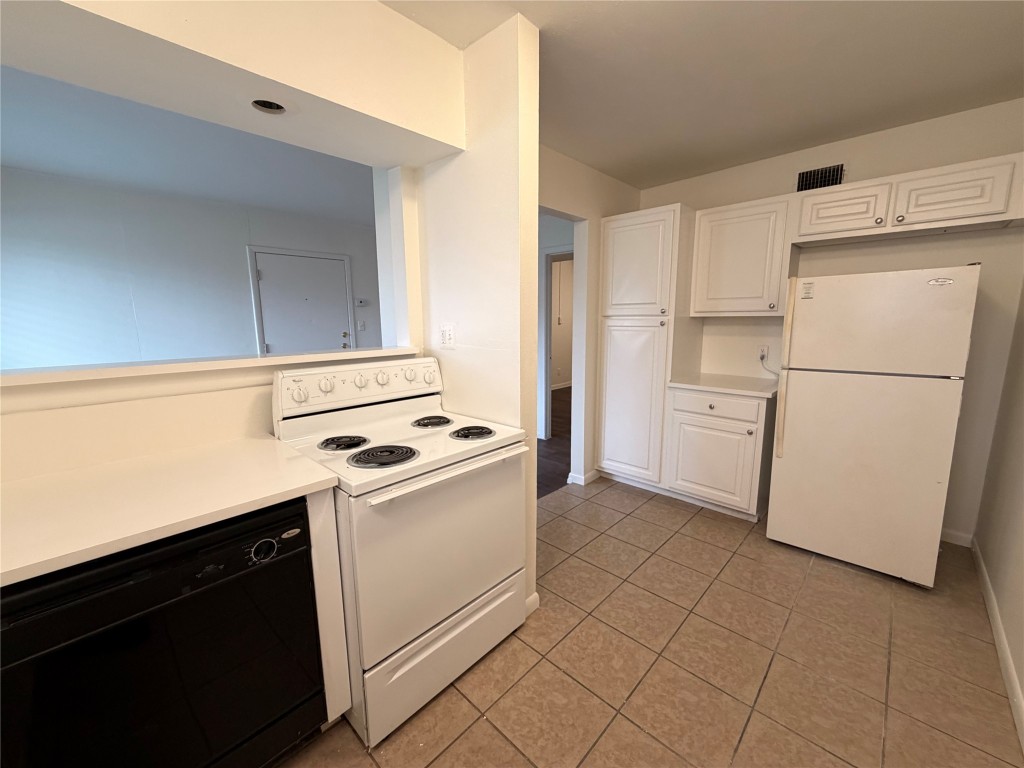3304 Red River Street, Unit 206 Austin, TX 78705 - Photo 5 of 16 a kitchen with white cabinets and white appliances