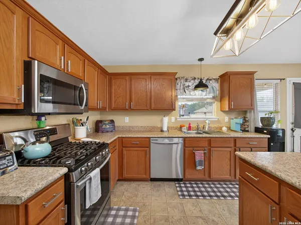 a kitchen with stainless steel appliances granite countertop a stove top oven a sink dishwasher and a microwave oven on the blue kitchen countertops