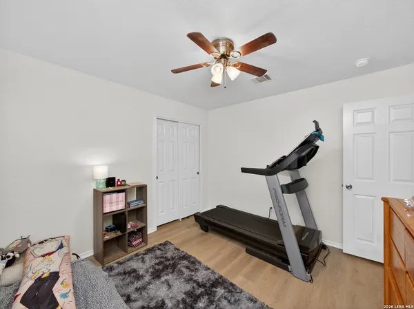 a room with gym equipment and a wooden floor