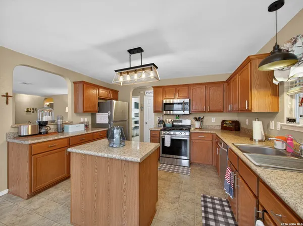 a kitchen with granite countertop a sink stainless steel appliances and cabinets