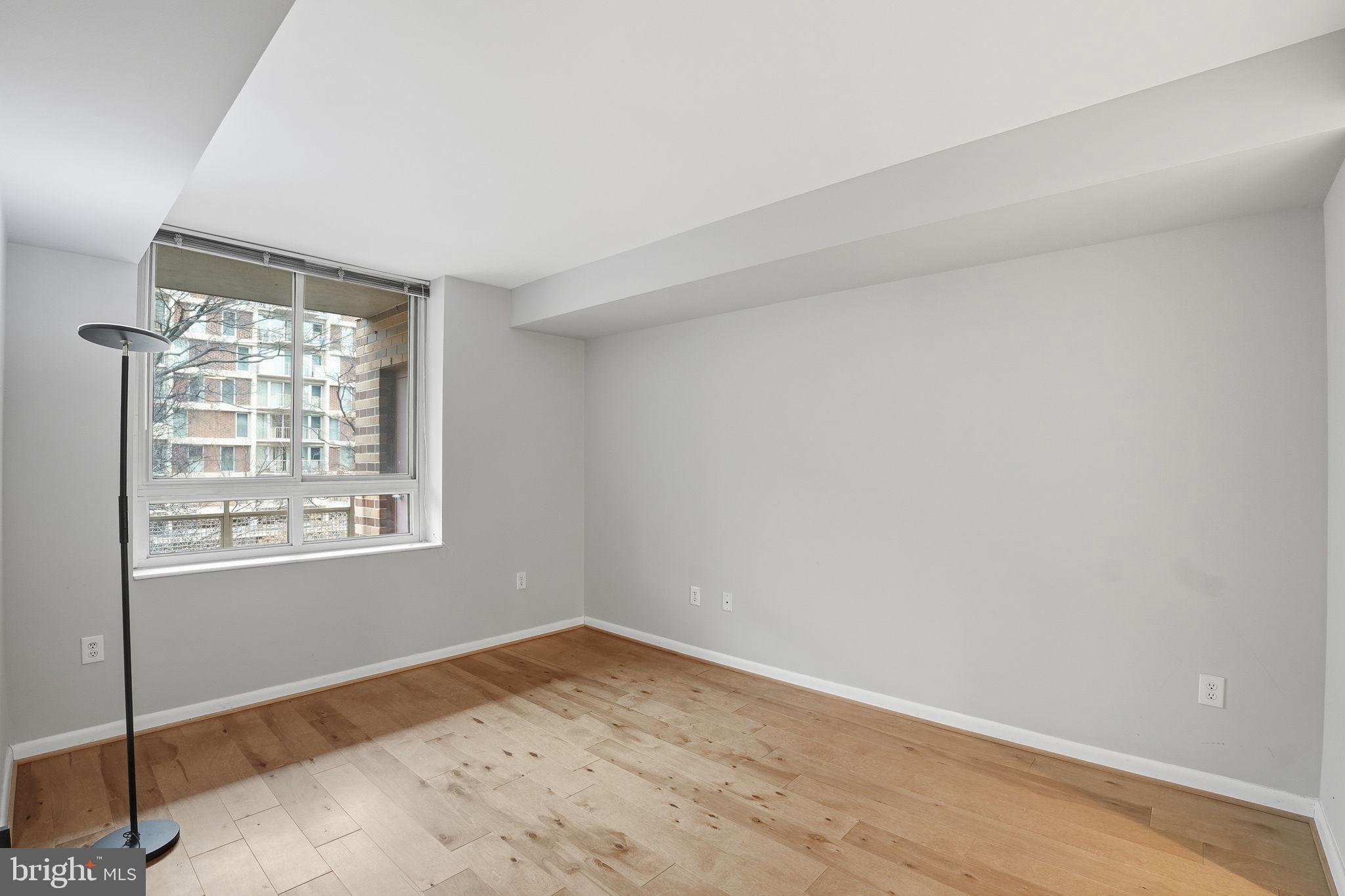 350 G Street Southwest, Unit N302 Washington, DC 20024 - Photo 9 of 32 an empty room with wooden floor and windows