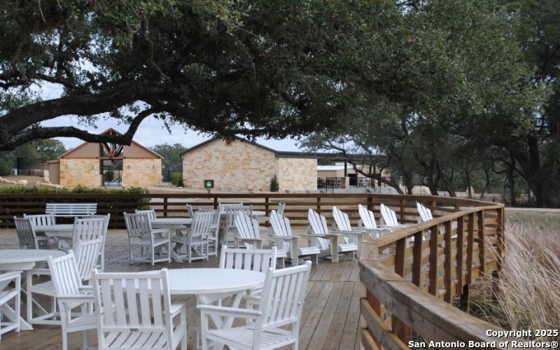 Lot 371 West Nicholas Weeks Blanco, TX 78606 - Photo 17 of 18 a view of a patio with table and chairs with wooden fence and large trees