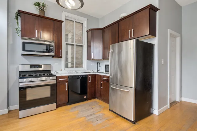 a kitchen with stainless steel appliances granite countertop a refrigerator stove and microwave
