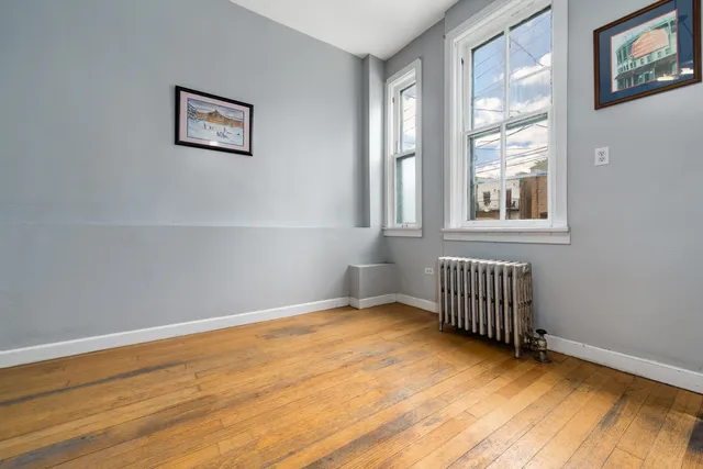 a view of a room with wooden floor and windows
