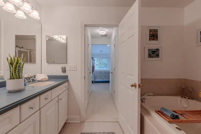 a bathroom with a tub sink and mirror