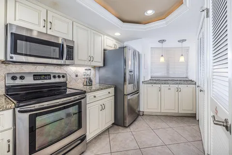 a kitchen with stainless steel appliances granite countertop a stove a microwave and a refrigerator