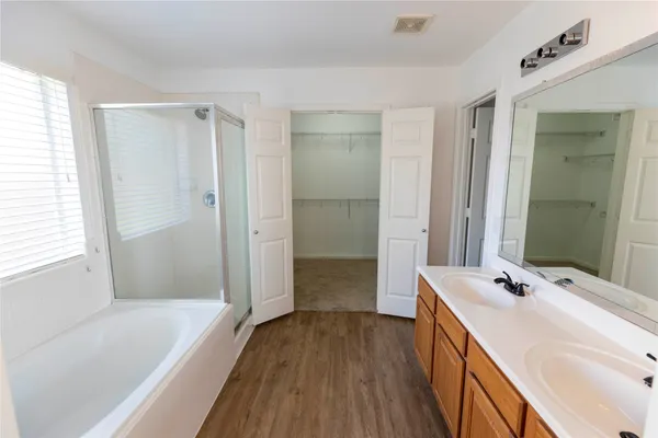 a bathroom with a tub sink and mirror
