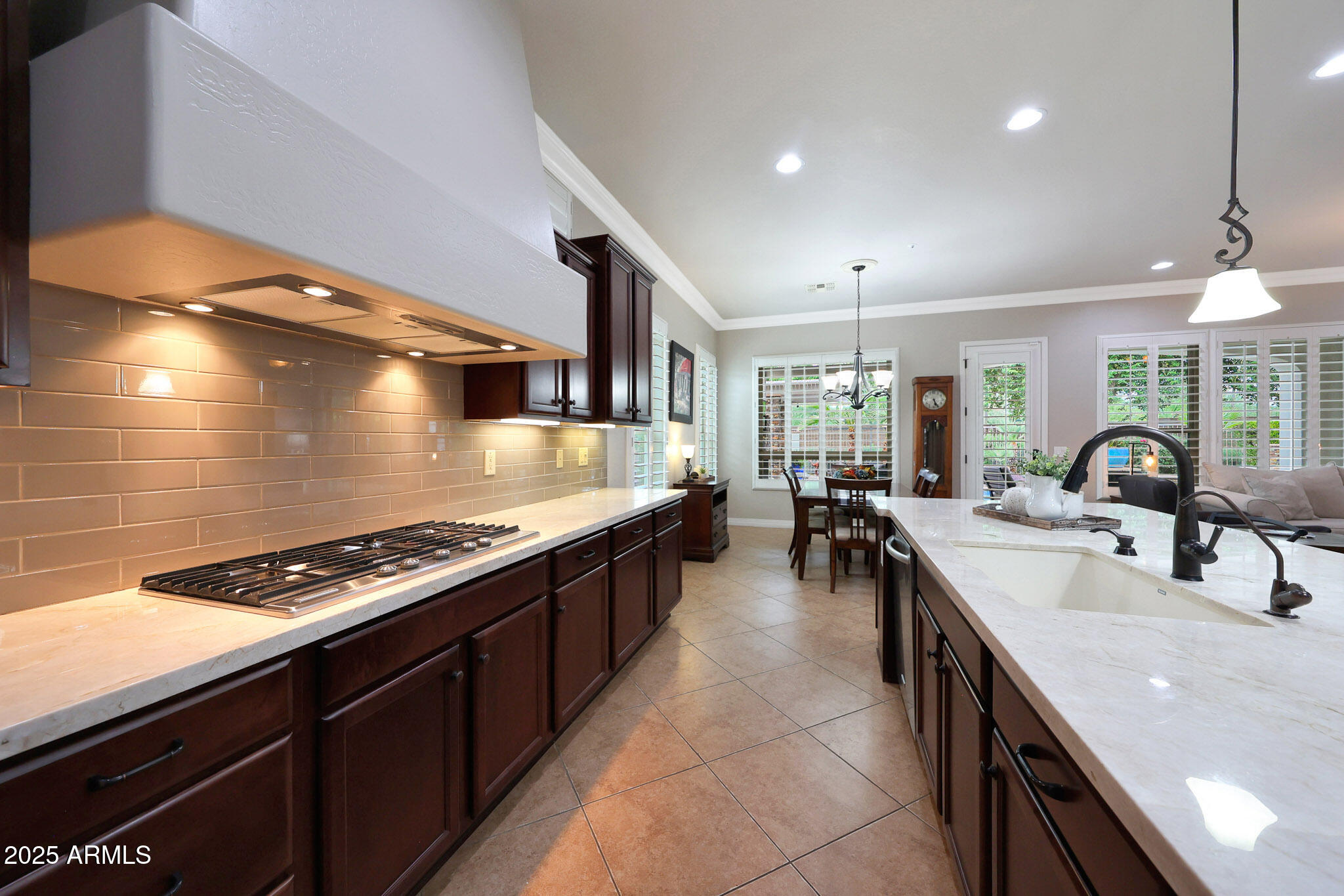 12920 West Roy Rogers Road Peoria, AZ 85383 - Photo 11 of 85 a large kitchen with stainless steel appliances a stove a sink dishwasher and a dining table with the living room view