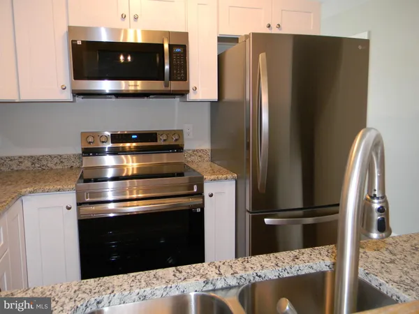 a kitchen with stainless steel appliances kitchen island a refrigerator and a stove