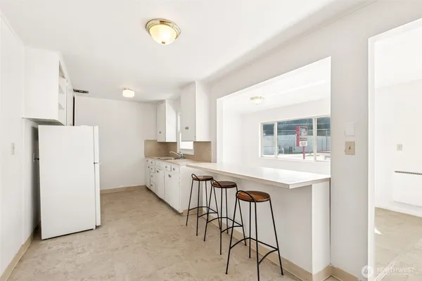 a kitchen with a sink a refrigerator and cabinets