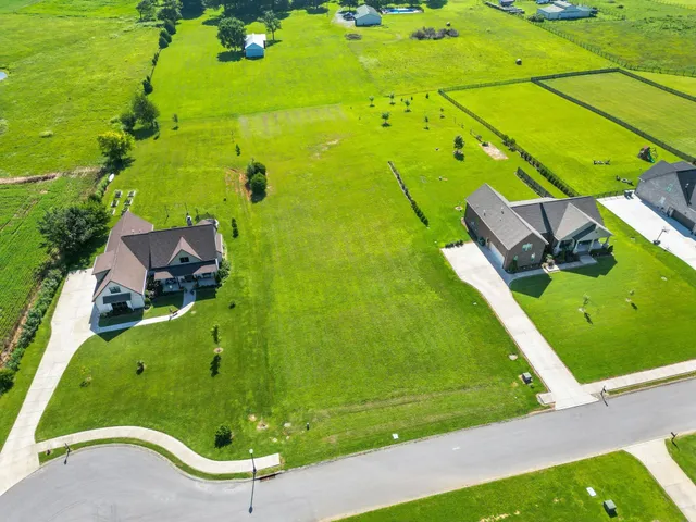 an aerial view of a residential houses with outdoor space and street view