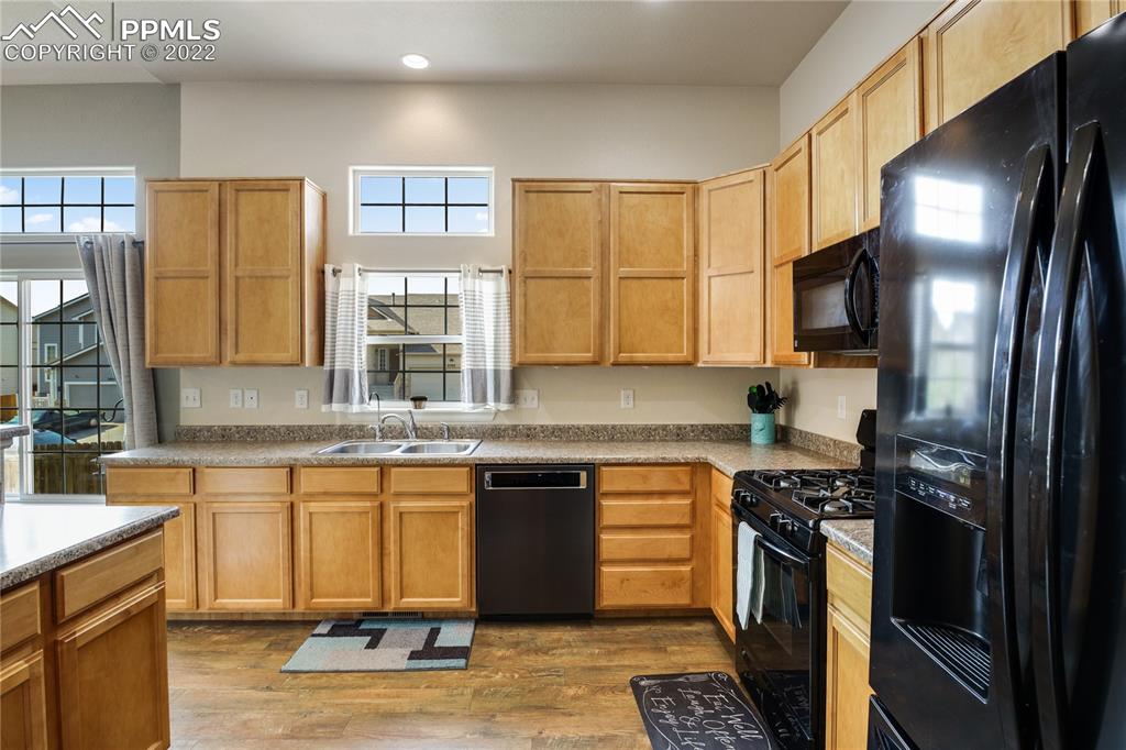 6446 Dancing Moon Way Colorado Springs, CO 80911 - Photo 12 of 42 a kitchen with stainless steel appliances granite countertop a stove a sink and a microwave
