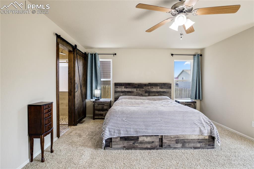 6446 Dancing Moon Way Colorado Springs, CO 80911 - Photo 14 of 42 a bedroom with a bed and a chandelier