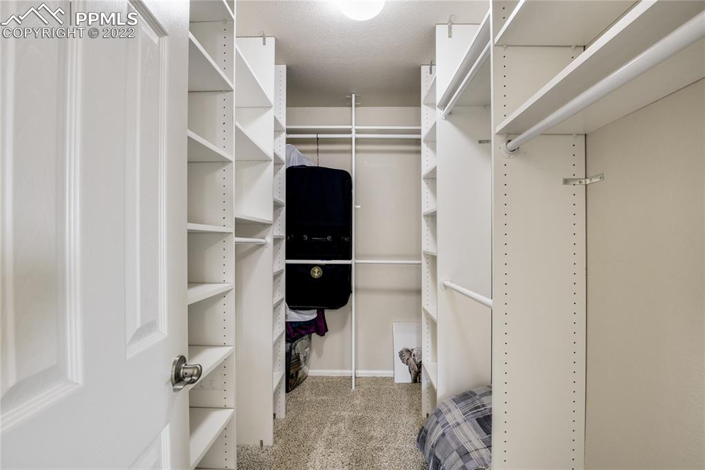 6446 Dancing Moon Way Colorado Springs, CO 80911 - Photo 16 of 42 a view of walk in closet with clothes and shoes