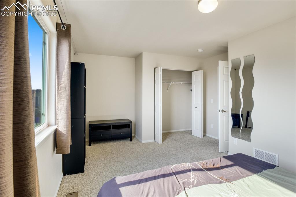 6446 Dancing Moon Way Colorado Springs, CO 80911 - Photo 23 of 42 a bedroom with a bed and a walk in closet